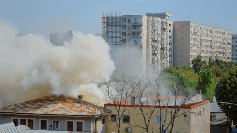 Flames going out from burning house in neighbourhood